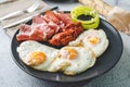 Close up view on sunny side up eggs prosciutto coppa Capocollo dry meat and homemade ajvar paprika salad in plate on the table as