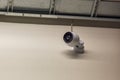Close-up view of a surveillance camera mounted on a wall in a warehouse. Security concept. Royalty Free Stock Photo