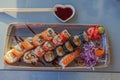 Close-up view of a sushi platter with various sushi, sauce, and wooden chopsticks on the table in a restaurant. Royalty Free Stock Photo