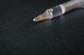 Close up view of a syringe and a needle with a drop on dark gray background. Flu shot or drug abuse concept. Royalty Free Stock Photo