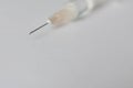 Close up view of a syringe and a needle with a drop on white background. Flu shot or drug abuse concept. Royalty Free Stock Photo