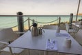 Close-up view of table with cutlery for breakfast in open-air restaurant overlooking Atlantic Ocean. Royalty Free Stock Photo