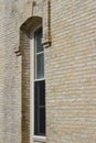 Close up view of a tall narrow arched window on a beige brick wall texture background Royalty Free Stock Photo