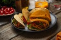 Close-up view of tasty mexican tacos on black round plate on rustic wooden table. Traditional mexican cuisine. Ingredients for Royalty Free Stock Photo