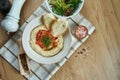 Close up view on tasty plate of arabic, israel or lebanese vegetarian hummus made from chickpeas with pita and vegetables