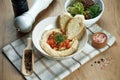 Close up view on tasty plate of arabic, israel or lebanese vegetarian hummus made from chickpeas with pita and vegetables