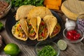 Close-up view of tasty street tacos with beef, tomatoes, onion and cheese on black round plate. Ingredients for cooking tacos on Royalty Free Stock Photo