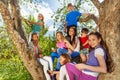 Close-up view of teens on the tree with mobiles