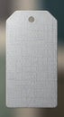 A close-up view of a textured, blank, white, rectangular tag wit Royalty Free Stock Photo