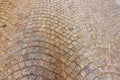 Close-up view of textured cobblestone pavement with intricate pattern, displaying natural stone colors.