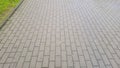 A close-up view of a textured pavement made of rectangular bricks, showcasing a layout of grey and beige colors. Ideal f Royalty Free Stock Photo