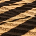 A close-up view of textured sand creating wave-like patterns with alternating light an Royalty Free Stock Photo