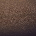 A close-up view of a textured surface resembling fine sand or grains. The surface Royalty Free Stock Photo