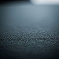 A close-up view of a textured surface with tiny, evenly spaced bumps creating a rough appearance.