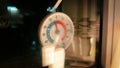 Close-up view of thermometer hanging on window pane glass outdoors. Minus -4 degrees Celcius. Winter time. Macro Royalty Free Stock Photo