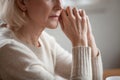 Close up view of thoughtful mature woman worried about problems