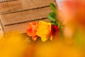 Close up view of three orange rose and red roses in a wood basket. Floral photography detail. Royalty Free Stock Photo