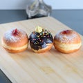 Close up view of three tasty various donuts on wood background. Hanukkah celebration concept.