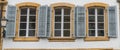 Close up view of three windows with wooden window shutters in blue Royalty Free Stock Photo