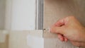 Close-up view of tiler hands fixing wall tile with spacers at home repair renovation work. Laying tiles on the wall Royalty Free Stock Photo