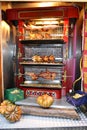 Roasted chickens and porc rolling over roasted vegetables in a grilling box with refraction. Royalty Free Stock Photo