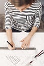 Close up view from top of concentrated young good-looking female architect making her new project for apartments, using Royalty Free Stock Photo