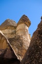 Close-up view top of the famous Fairy Chimneys or Multihead stone mushrooms in Pasaba Valley near Goreme. Blue sky background. Royalty Free Stock Photo