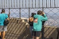 Close up view of tourists on open main observation desk of Empire State Building. New York.