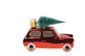 Close up view of toy figure car with pine tree on light white background isolated. Christmas holidays concept. Royalty Free Stock Photo