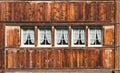 Traditional architectural detail of Appenzell style house front in old sunburned wood with many windows on a typical farmhouse in