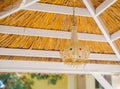 Close up view of a traditional bamboo lampshade hanging on the roof of the garden gazebo
