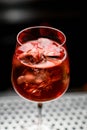 close-up view of transparent glass full of bright alcoholic cocktail with ice cubes