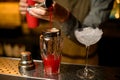 Close-up view of transparent glass shaker into which pours tomato juice from jigger and glass with ice Royalty Free Stock Photo