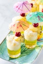 Close up view of a tray of pineapple jelly parfaits topped with shredded coconut and garnished with mini umbrella picks. Royalty Free Stock Photo