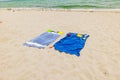 Close-up view of two beach towels and various household items laid out on the sandy shores of the Atlantic Ocean beach. Royalty Free Stock Photo