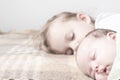 Close up view of two children, newborn baby,three year old girl sleeping together on beige bed. Sisters are sleeping on Royalty Free Stock Photo