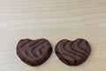 Close up view of two chocolate cookies in heart shape on wooden background. Royalty Free Stock Photo