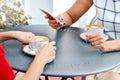 Two coffee cups and hands of young women with smartphone at outdoor cafe