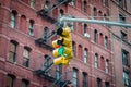 Close Up View of Typical New York City Yellow Traffic Lights. Building with Fire Escape Ladders in Background Royalty Free Stock Photo