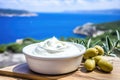 Close up view of tzatziki on Greek table, sea in background