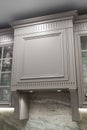 close-up view of under cabinet range hood, exhaust vent hood in kitchen with working lights and marble backsplash