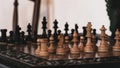 Close up view of unique wood hand crafted chess set pieces on wooden chess board Royalty Free Stock Photo