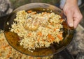 Close-up view of uzbek pilaf plate. View over the iron cauldron