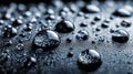 Close-up view of various reflective water droplets scattered on a dark textured surface creating a moody and abstract background Royalty Free Stock Photo