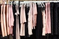 Close-up view of various stylish clothes hanging on hangers in boutique. Clothes