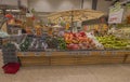 Close up view of vegetable department with variety of vegetables and fruits on supermarket shelves.