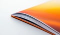 Close-up view of a vibrant orange notebook, its pages open, providing ample white space. Royalty Free Stock Photo