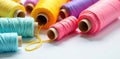 Close-up view of vibrant pastel-colored thread spools arranged on a pristine white surface. Generative AI Royalty Free Stock Photo
