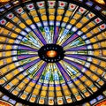 A close-up view of a vibrant stained glass ceiling, casting a kaleidoscope of colors and patterns below1, Generative AI