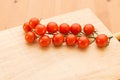 Close up view of vine tomatoes on a wooden board. Royalty Free Stock Photo